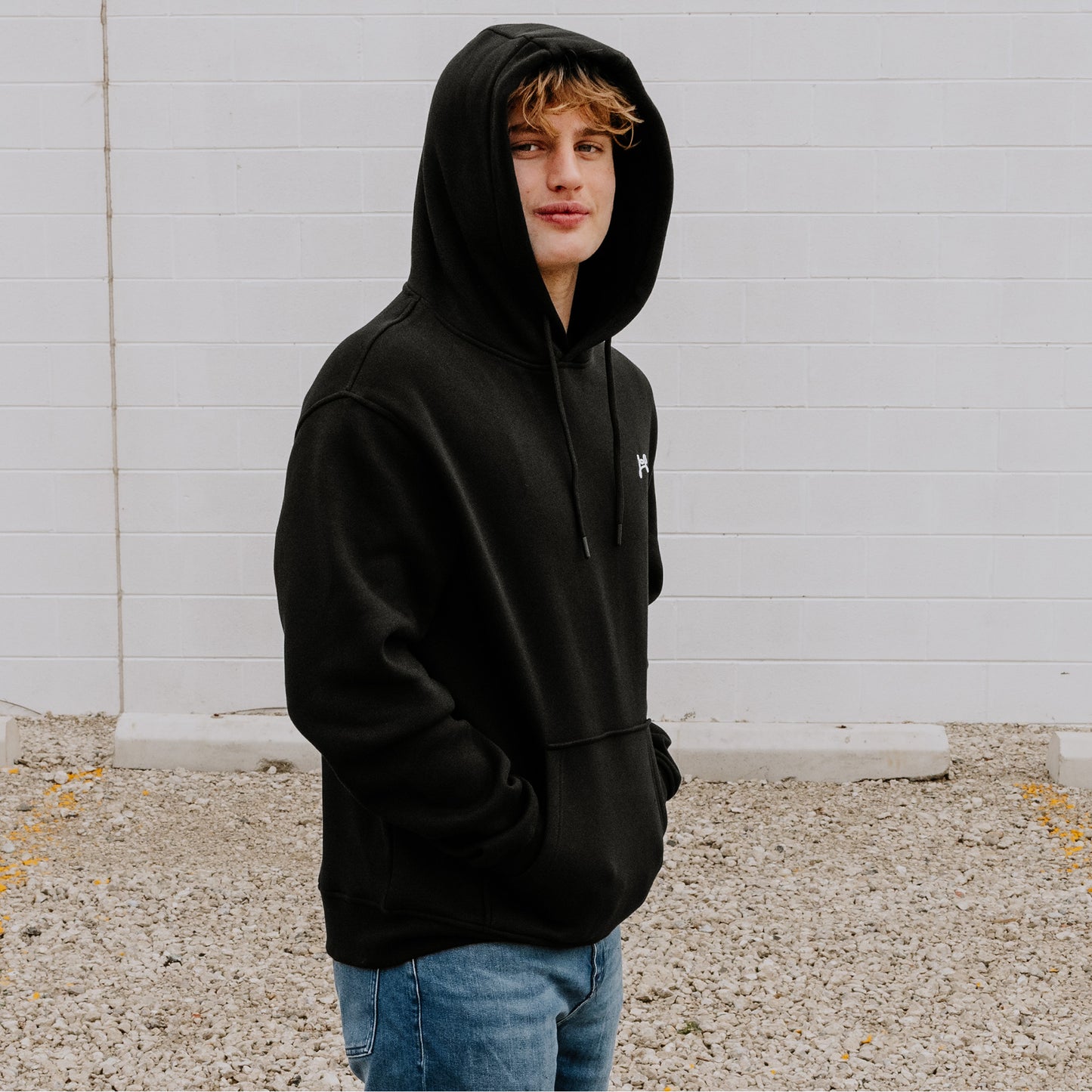 Model wearing OOsmash Connected hoodie in black, featuring soft cotton-poly fabric.