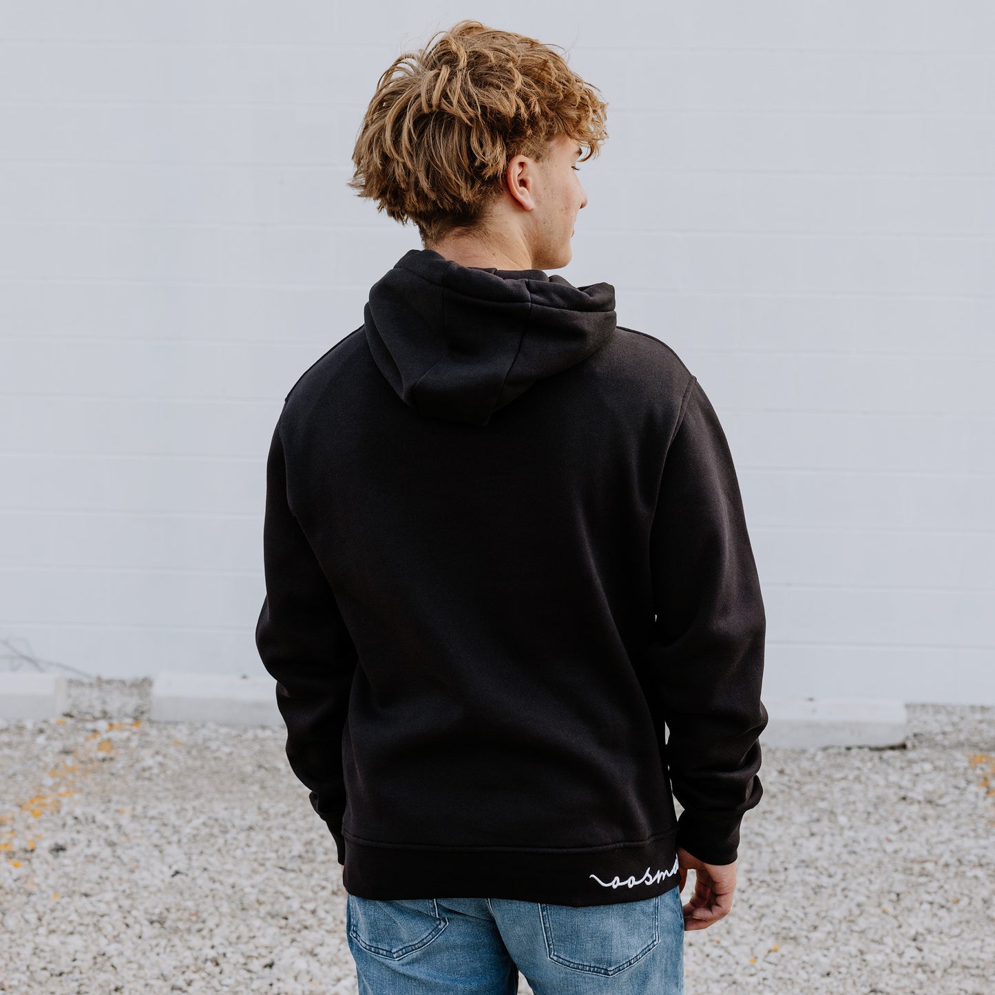 Model wearing OOsmash men’s black Signature hoodie featuring relaxed fit and adjustable hood.