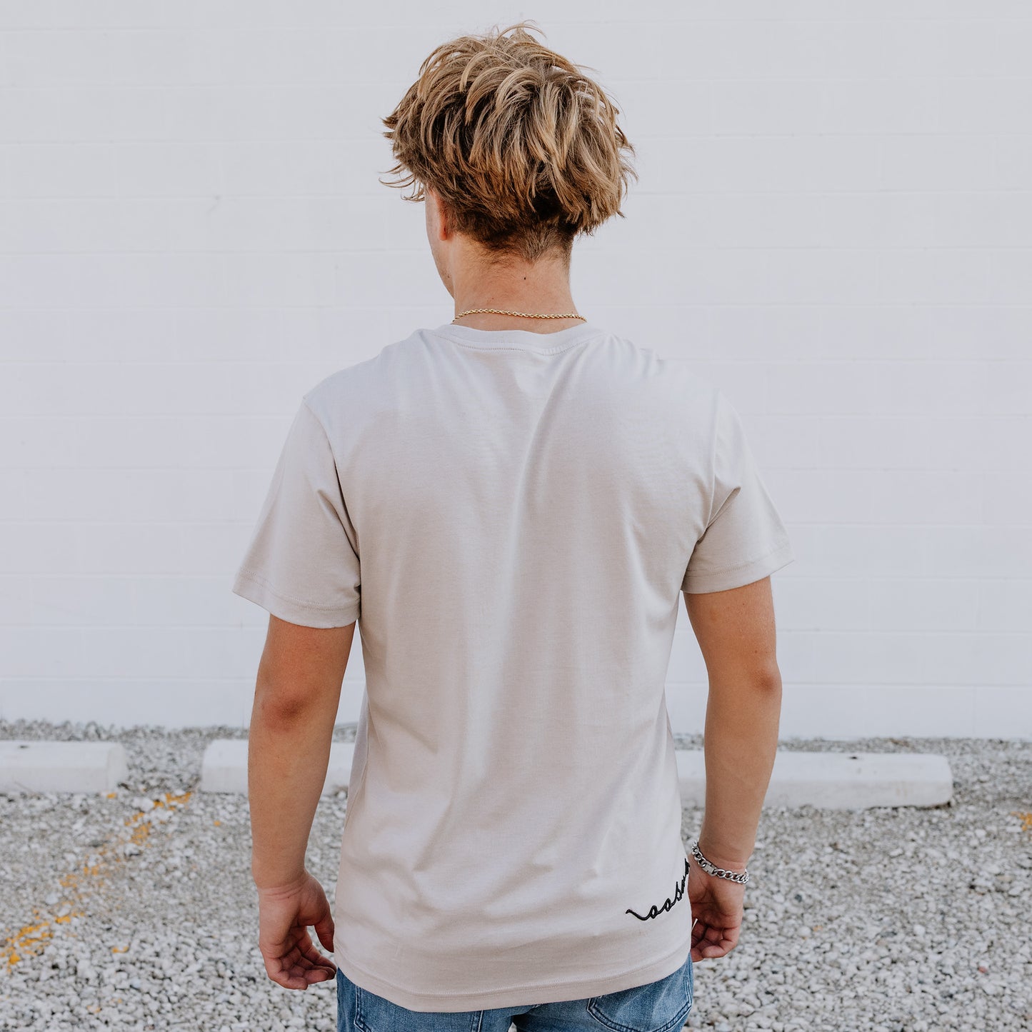 Model wearing OOsmash men’s beige T-Shirt featuring clean seams and relaxed fit.