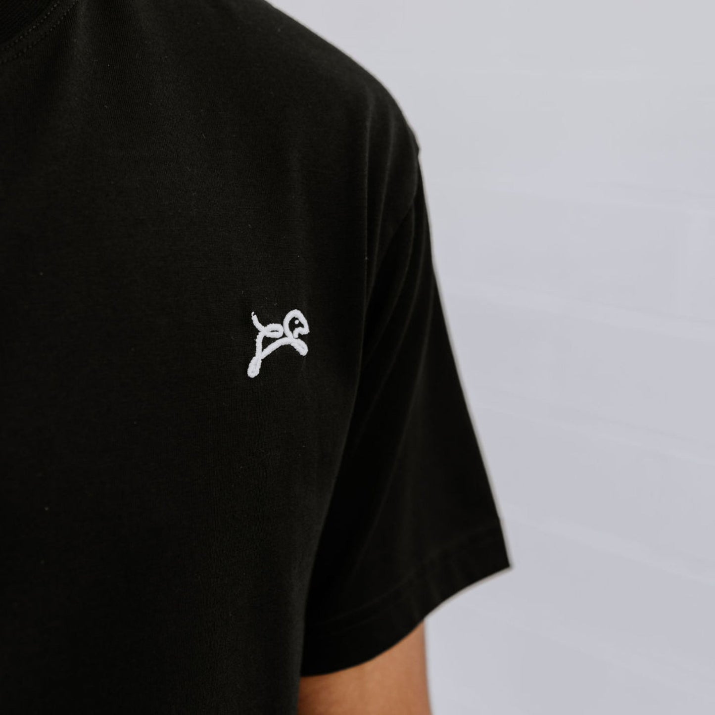 Model wearing OOsmash men’s black T-Shirt featuring premium stitching and relaxed fit.