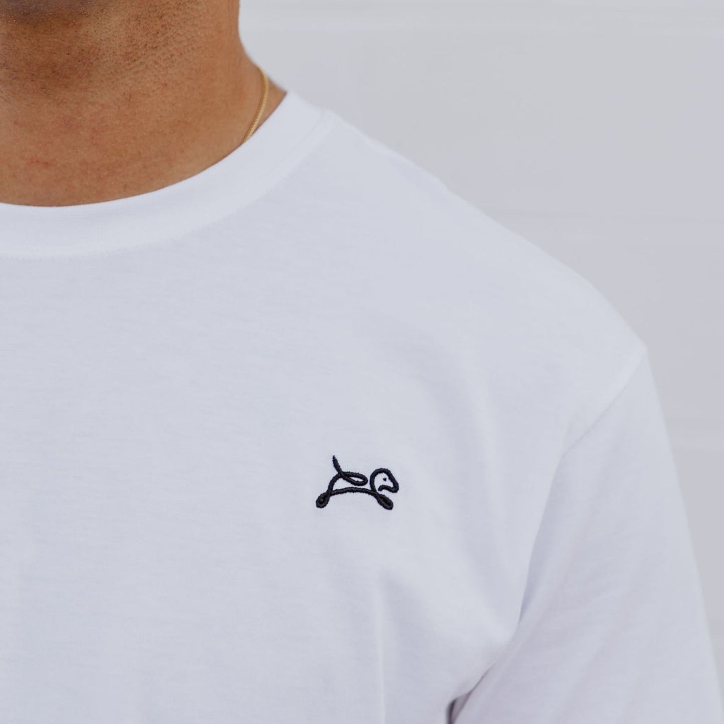 Model wearing OOsmash men’s white T-Shirt featuring clean stitching and relaxed fit.