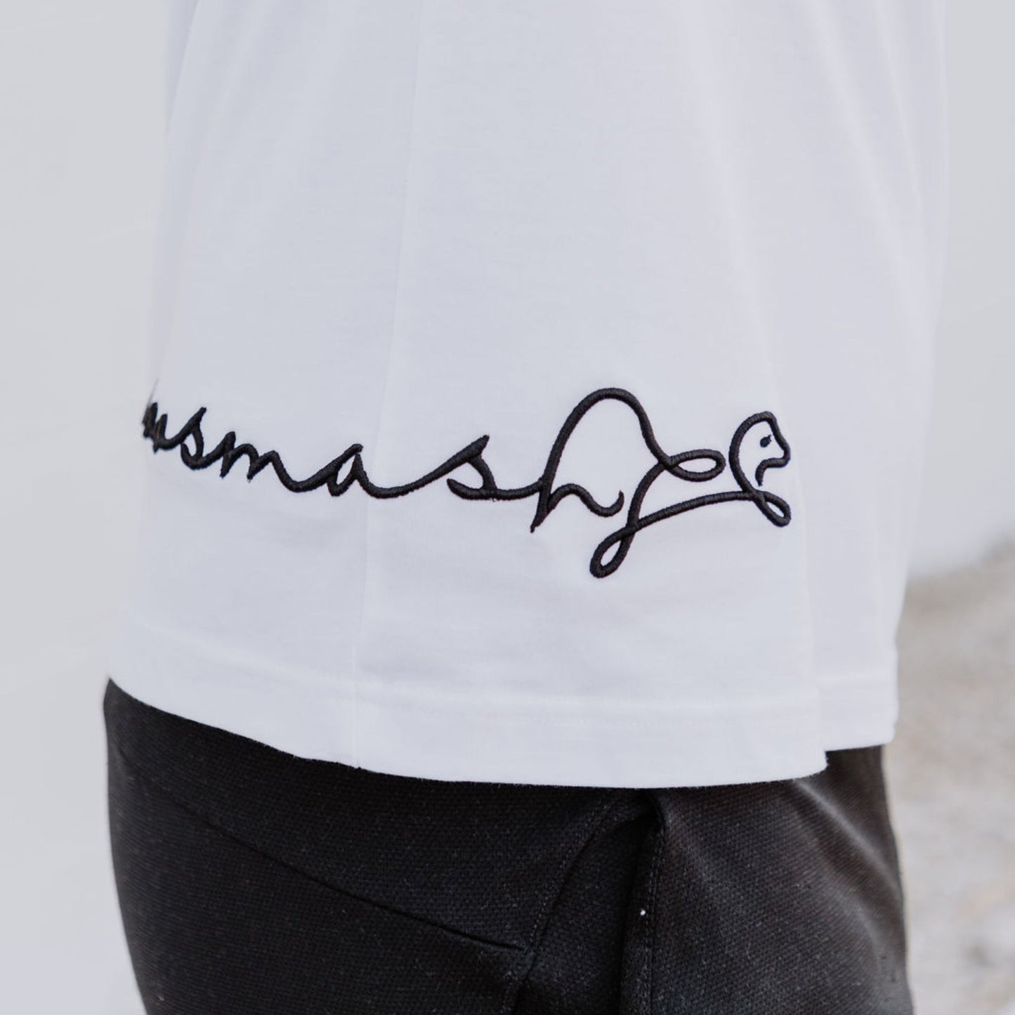 Model wearing OOsmash men’s white T-Shirt featuring clean stitching and relaxed fit.