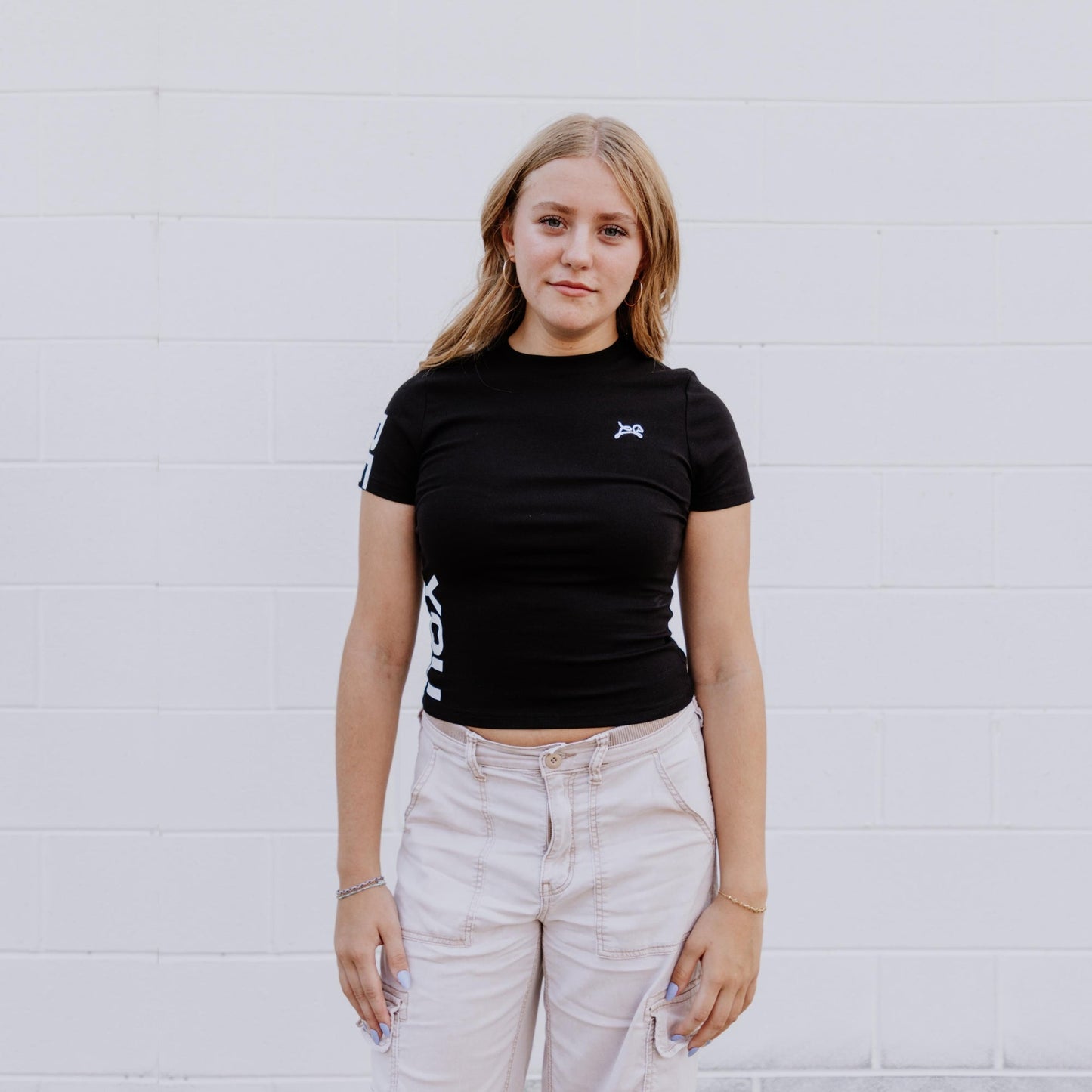 Model wearing OOsmash black crop tee featuring premium stretch fabric and flattering silhouette.