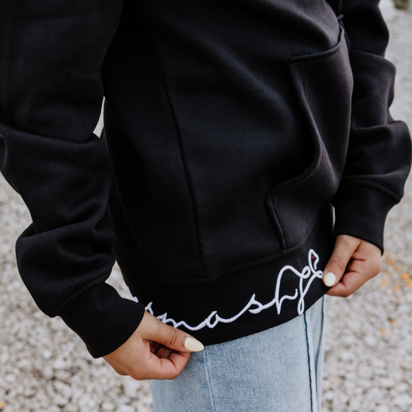 Black OOsmash Signature hoodie detail - bold 3D embroidered logo on hem