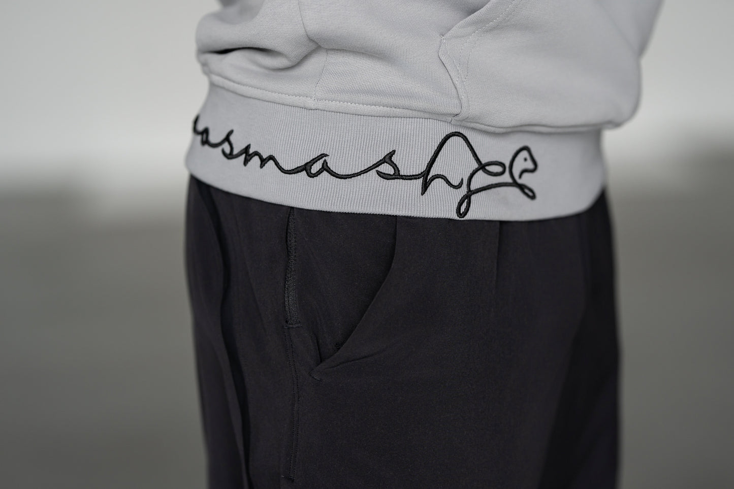 OOsmash Signature Hoodie — close-up signature embroidery detail on hem, artisan stitch luxury men's hoodie, OOsmash craftsmanship