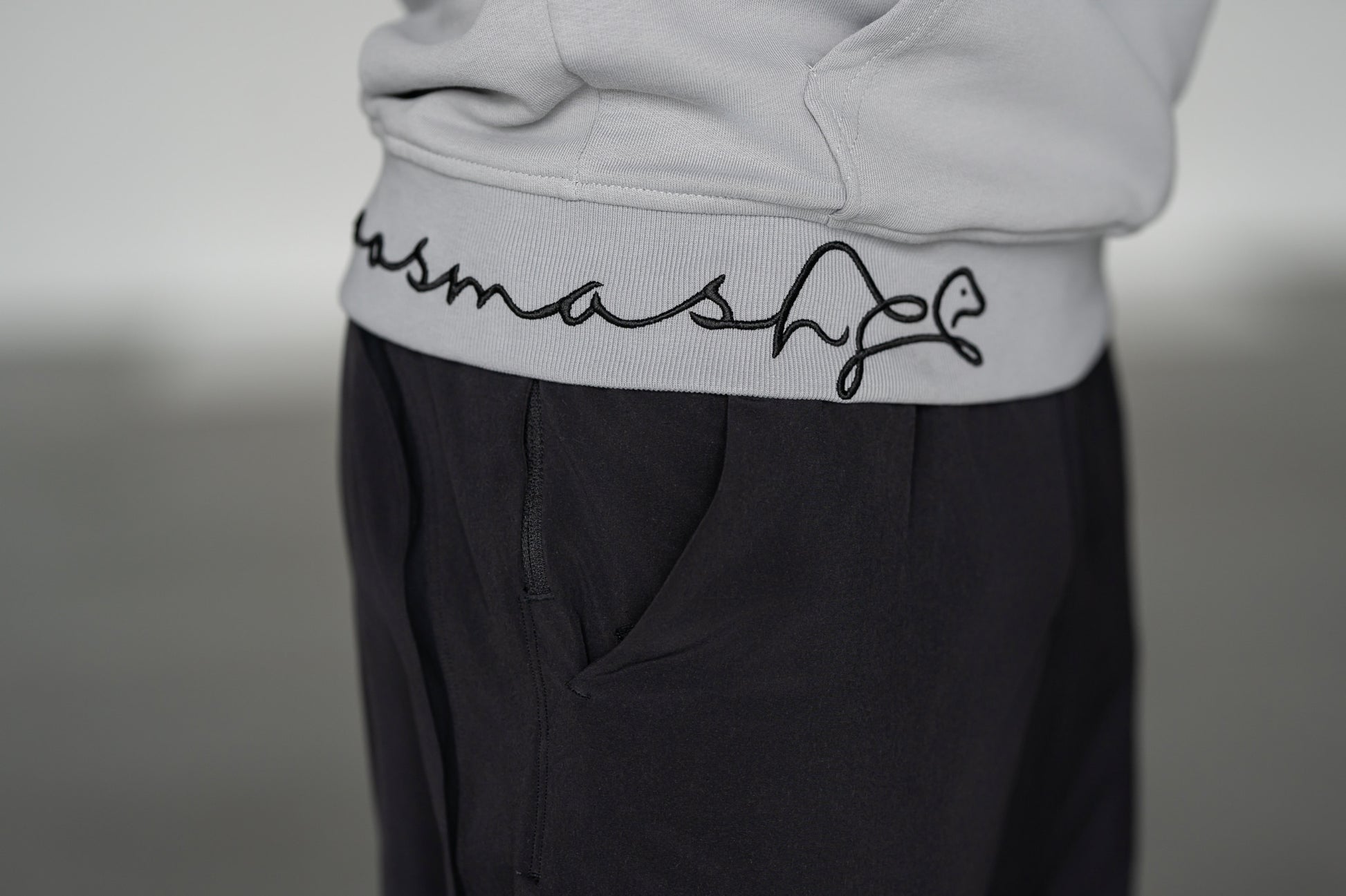 OOsmash Signature Hoodie — close-up signature embroidery detail on hem, artisan stitch luxury men's hoodie, OOsmash craftsmanship