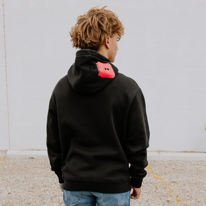 Model wearing OOsmash men’s black hoodie featuring bold red plug accent and relaxed fit.