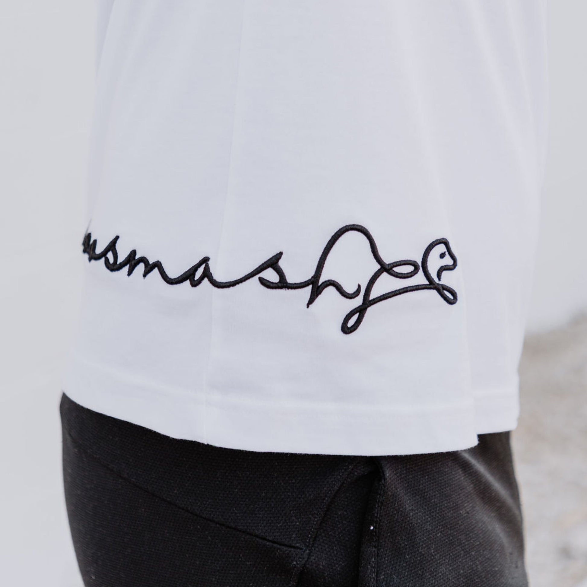 Model wearing OOsmash men’s white T-Shirt featuring clean stitching and relaxed fit.