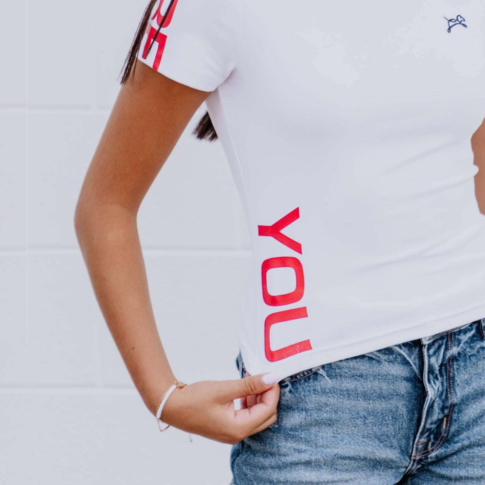 Model wearing OOsmash white crop tee featuring smooth fabric and flattering cropped cut.