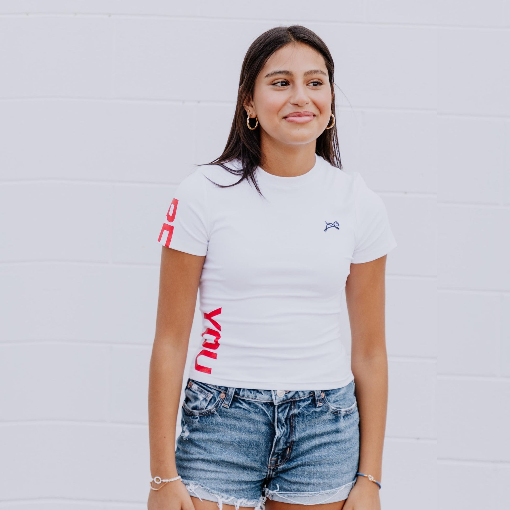 Model wearing OOsmash white crop tee featuring smooth fabric and flattering cropped cut.