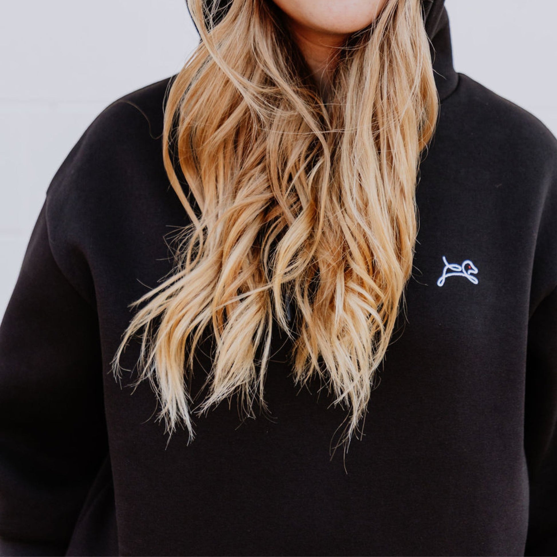 Model wearing OOsmash women’s black hoodie featuring bold red plug graphic.